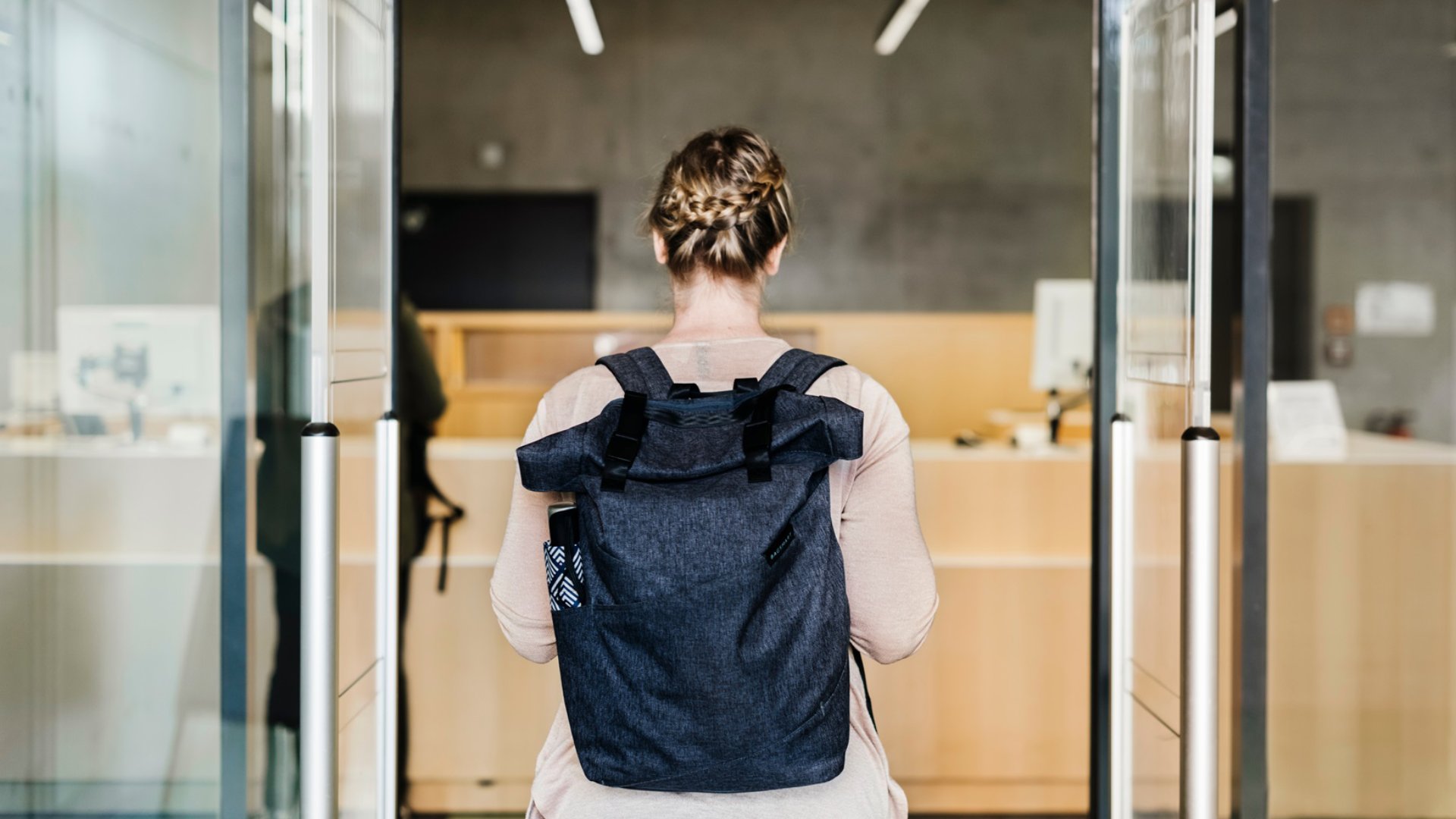 Woman Walking Through Library Entrance