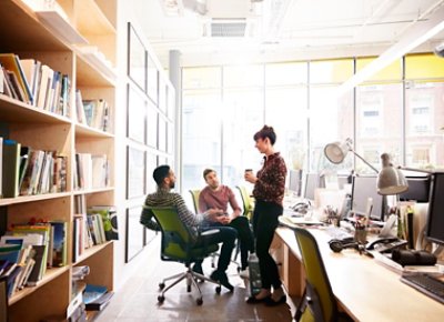 Three People Sitting Standing Talking