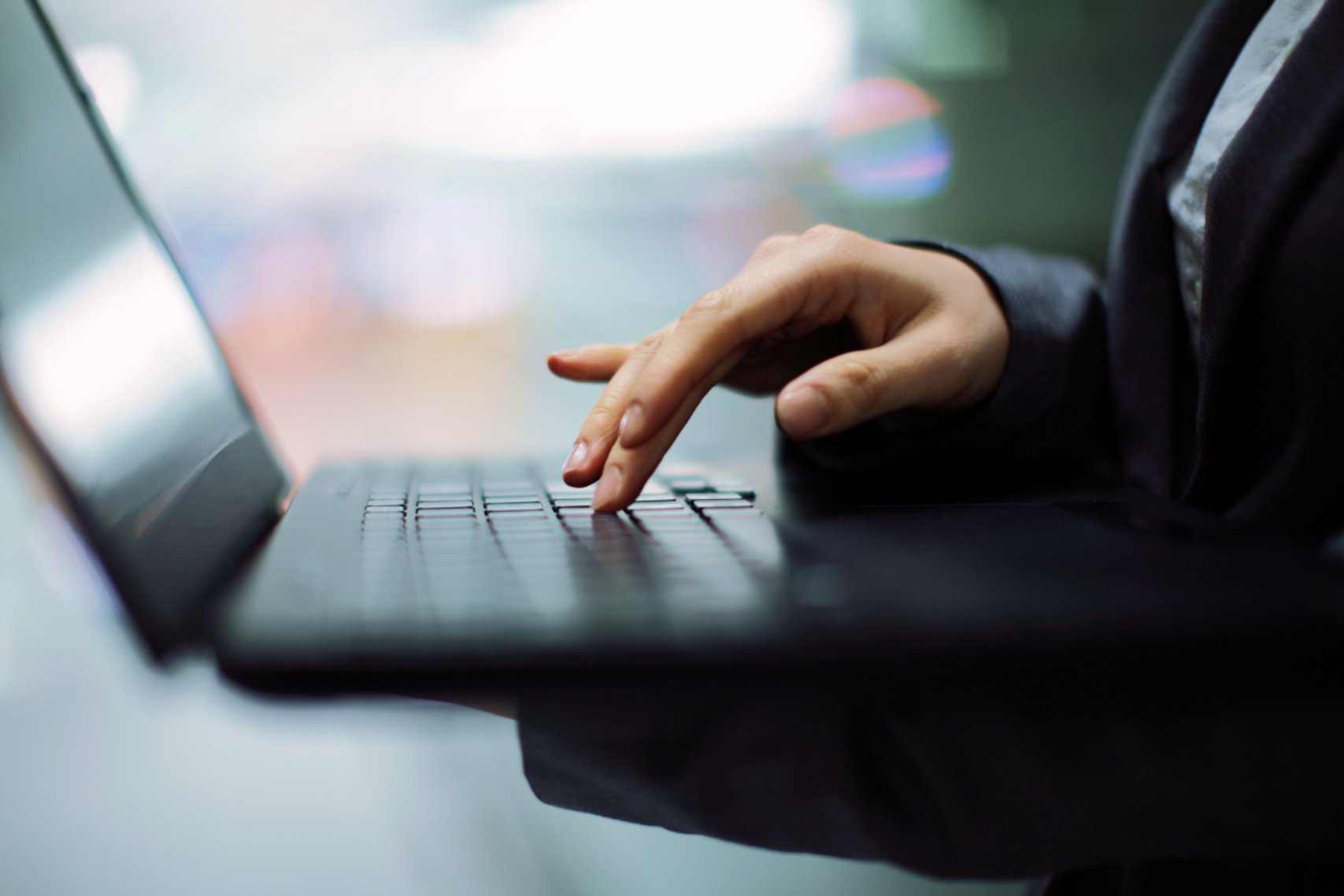 The person is typing on the keyboard with their hands