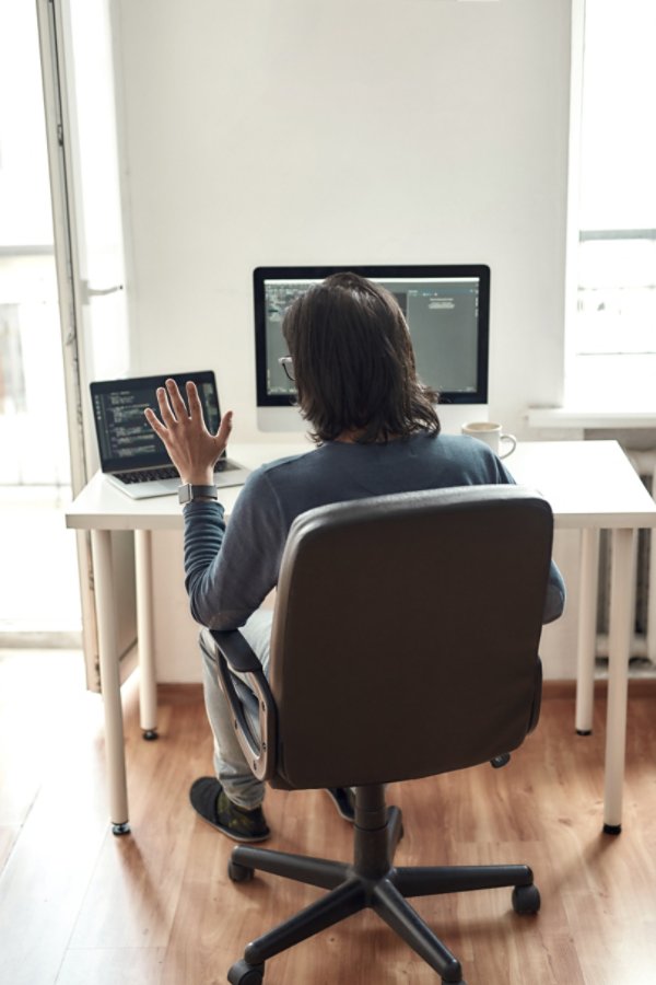 A person sitting at a desk with a laptop in an office setting