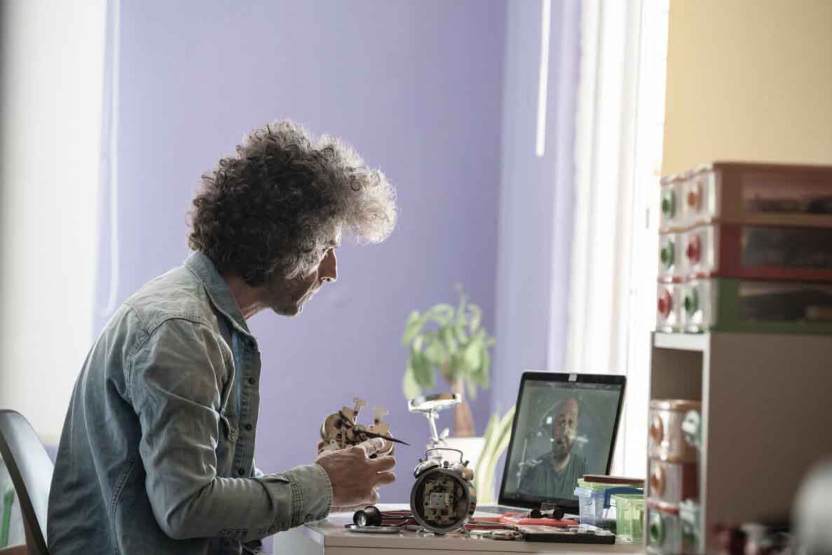 Curly haired man fixing something