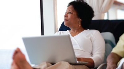 Woman using sitting in couch while using computer