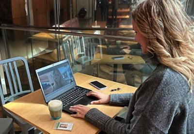 Woman using a laptop while drinking coffee