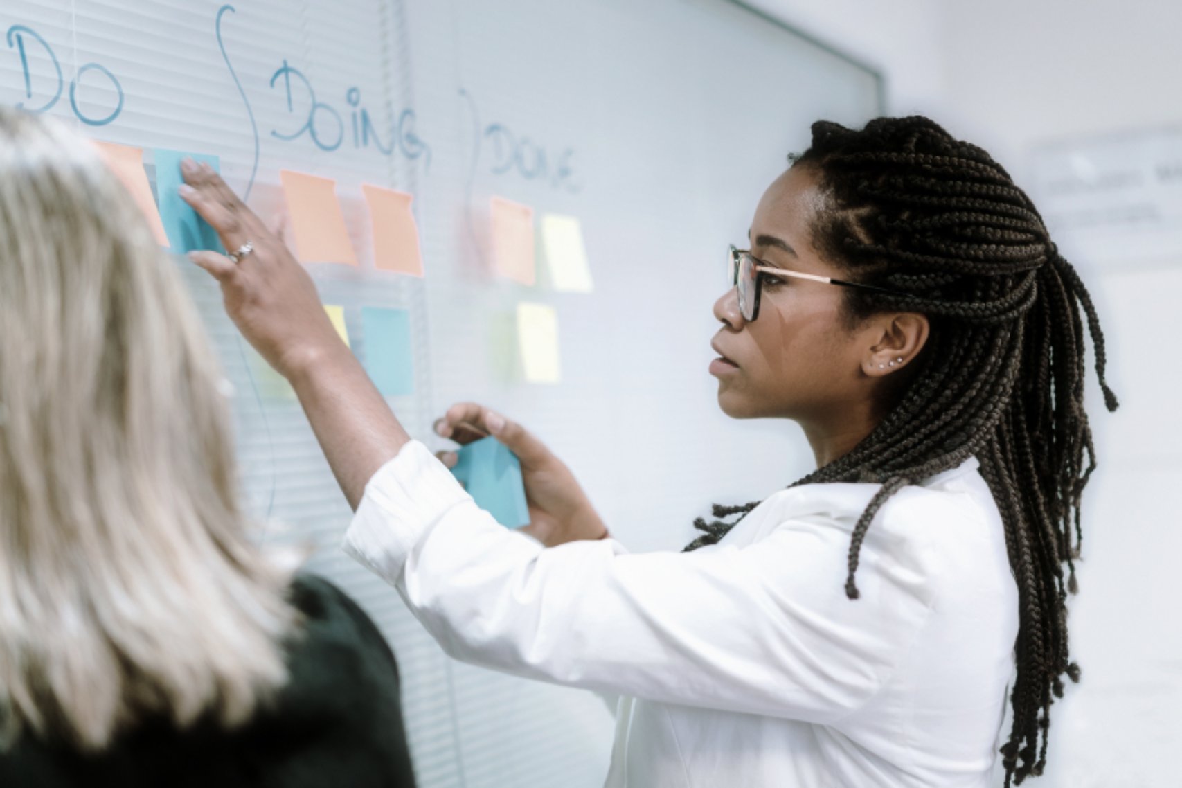 Woman Organizing Post Its On Board