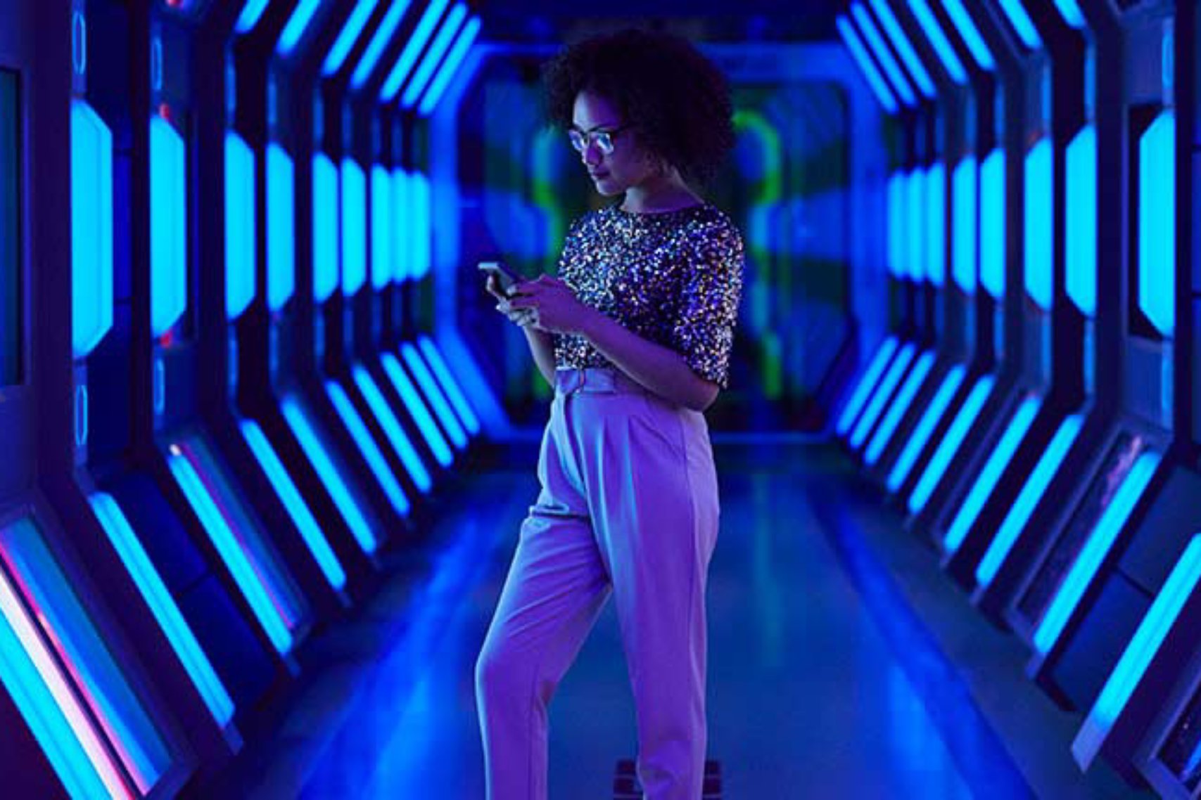 A woman standing inside a tunnel while holding a phone