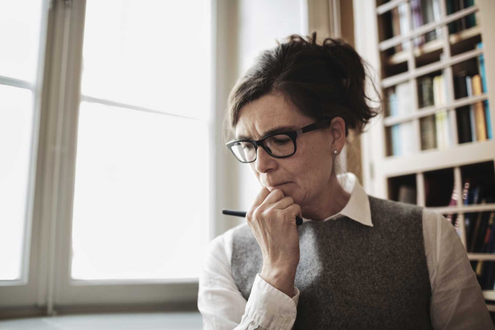 Woman with glasses hand on chin