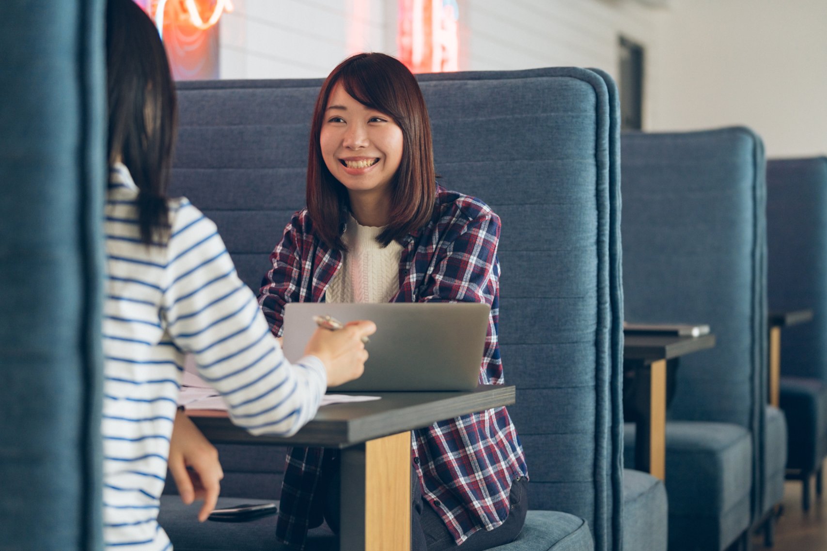 Women talking sitting on blue couch