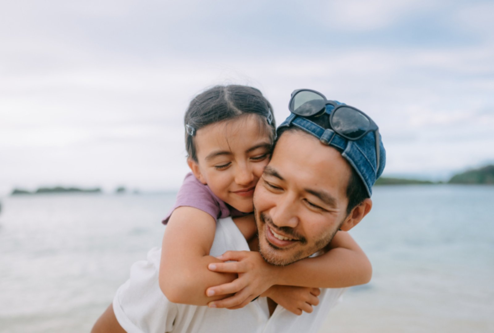 Father smiling and showing affection towards the child on his back