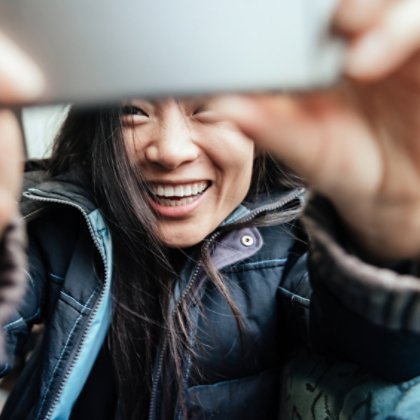 Young Asian Woman Taking Selfie In Train