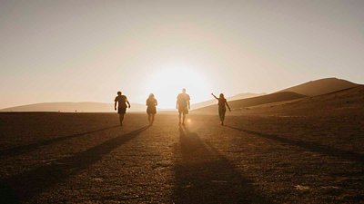 Group of people enjoying sunrise on the desert
