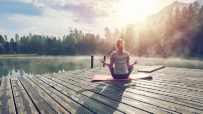 A picture of a girl meditate around the lake