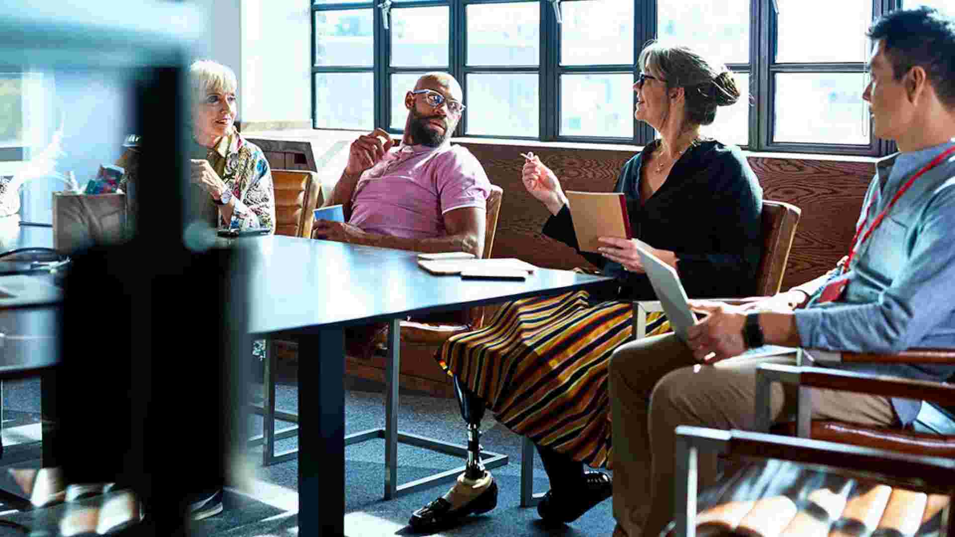 female businesswoman with prosthetic leg working with multi racial coworkers in business strategy review, leadership, knowledge, admiration