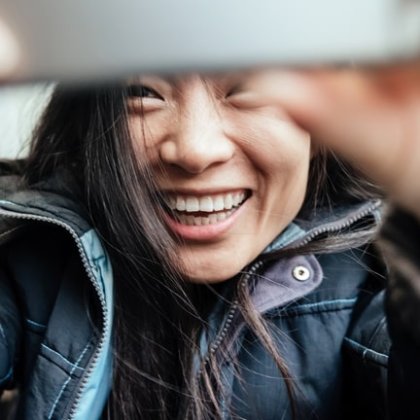 Young Asian Woman Taking Selfie In Train