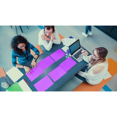 Group of people having a discussion looking at purple papers