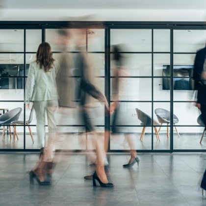 Blurred image of people walking in the office