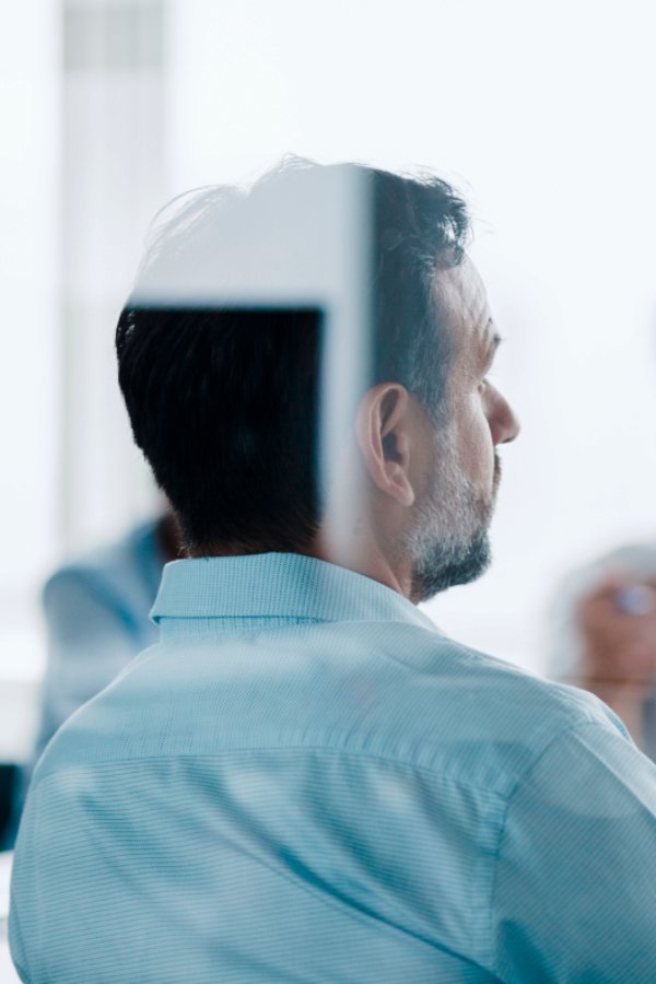 The backside of a business man listening to the meeting.