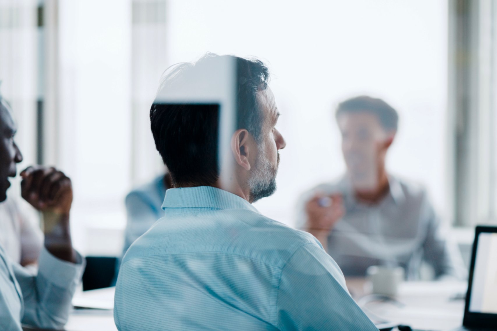 The backside of a business man listening to the meeting.