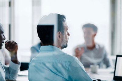 Indian male white collar worker in wheelchair discussion in office lounge with his colleague