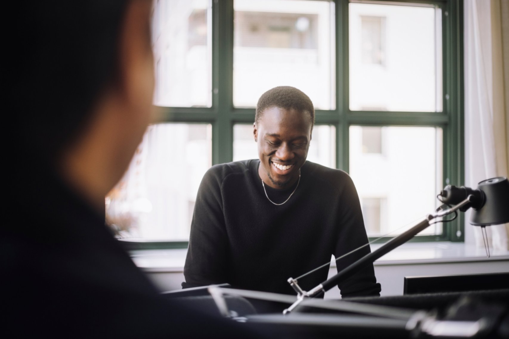 A man looks down smiling