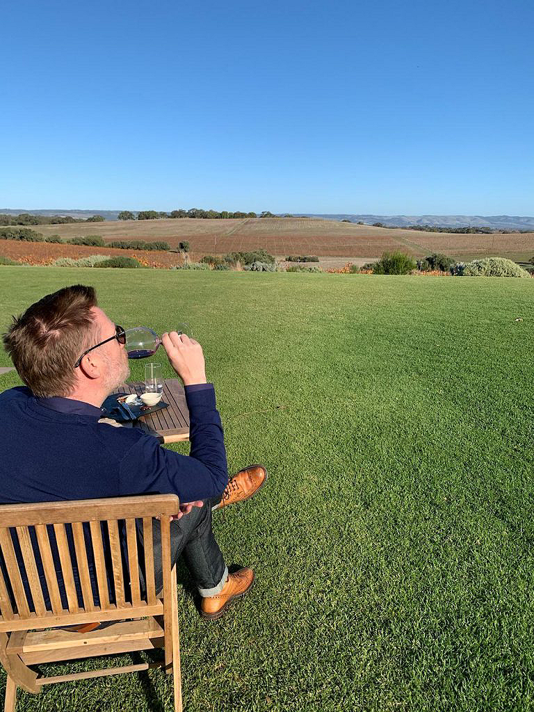 A man sipping wine while looking at the garden
