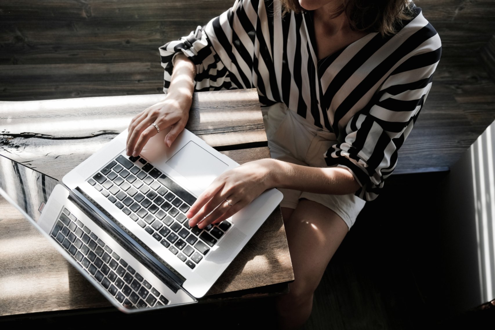 Woman sitting and typing on her laptop