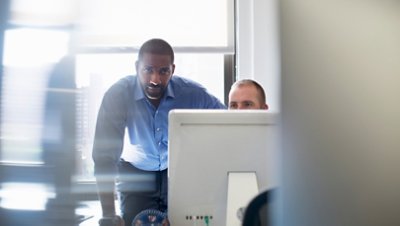 Two Men Discussing in Front of Computer JPG